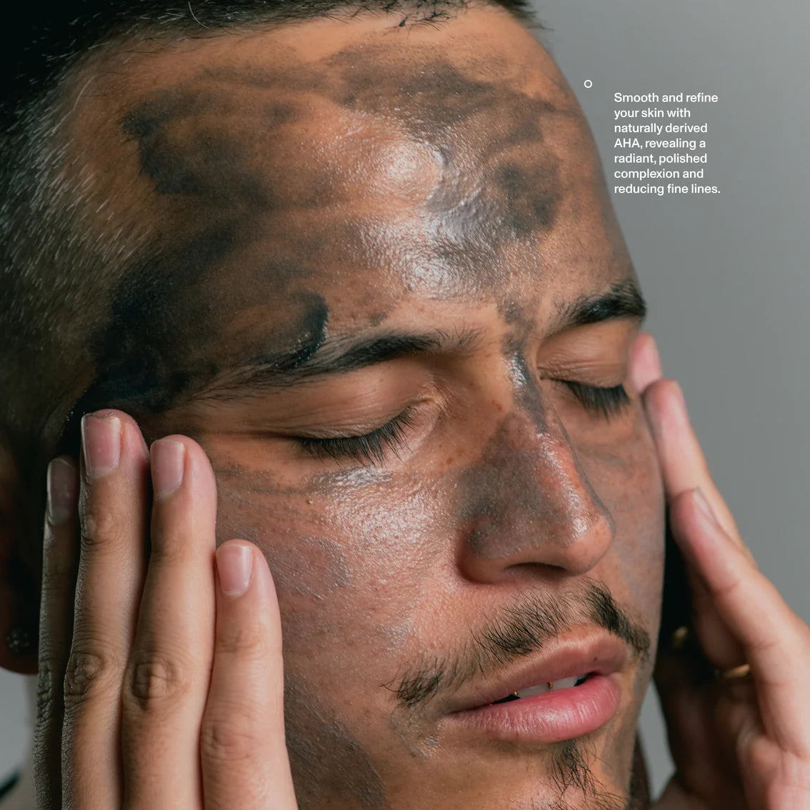 Close-up of a man applying a skincare product to his face with text about skin smoothing and refining.