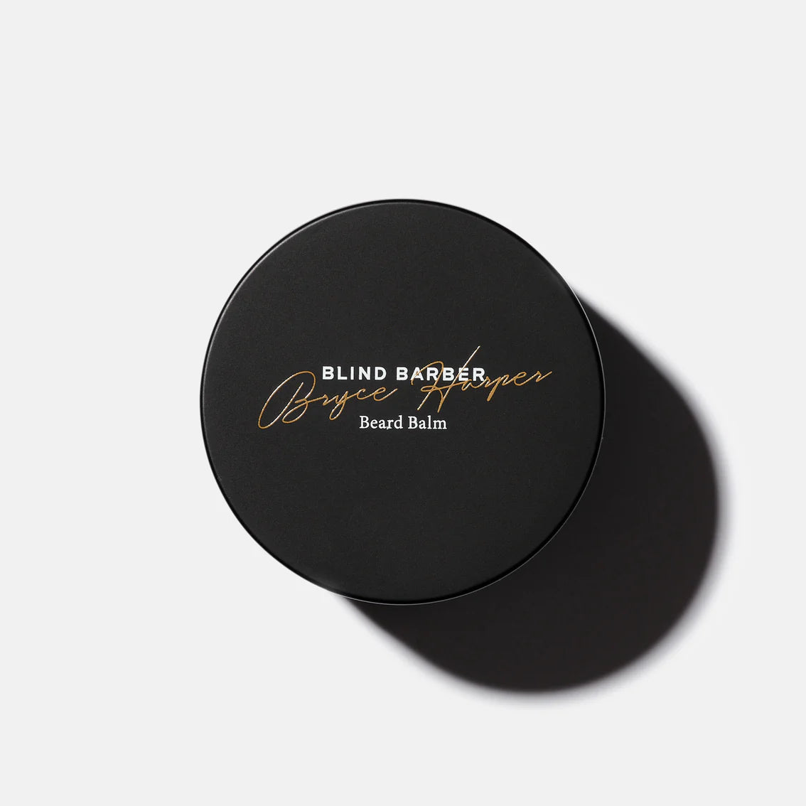 Black container of Blind Barber Bryce Harper Beard Balm on a light gray background