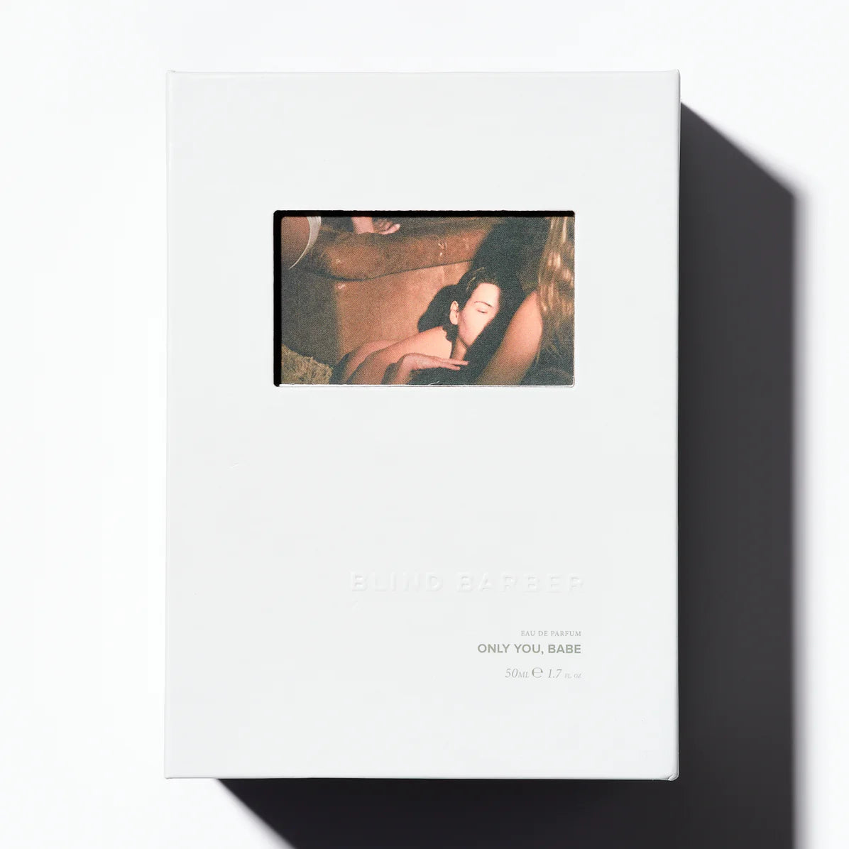 White album cover with a small inset image of a person lying down, on a white background.