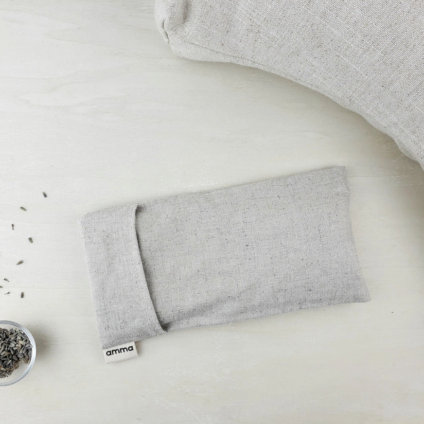 Gray eye pillow with lavender on a white surface