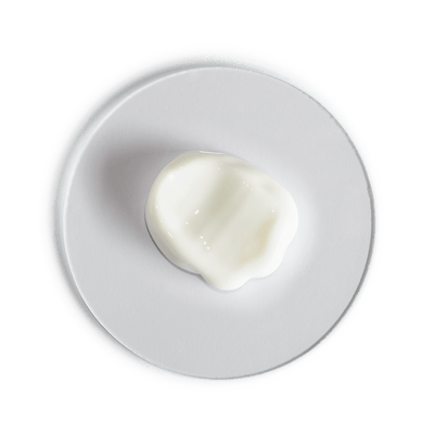 Heart-shaped white cream on a white plate with a black background