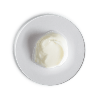 White yogurt container on a white plate with a black background