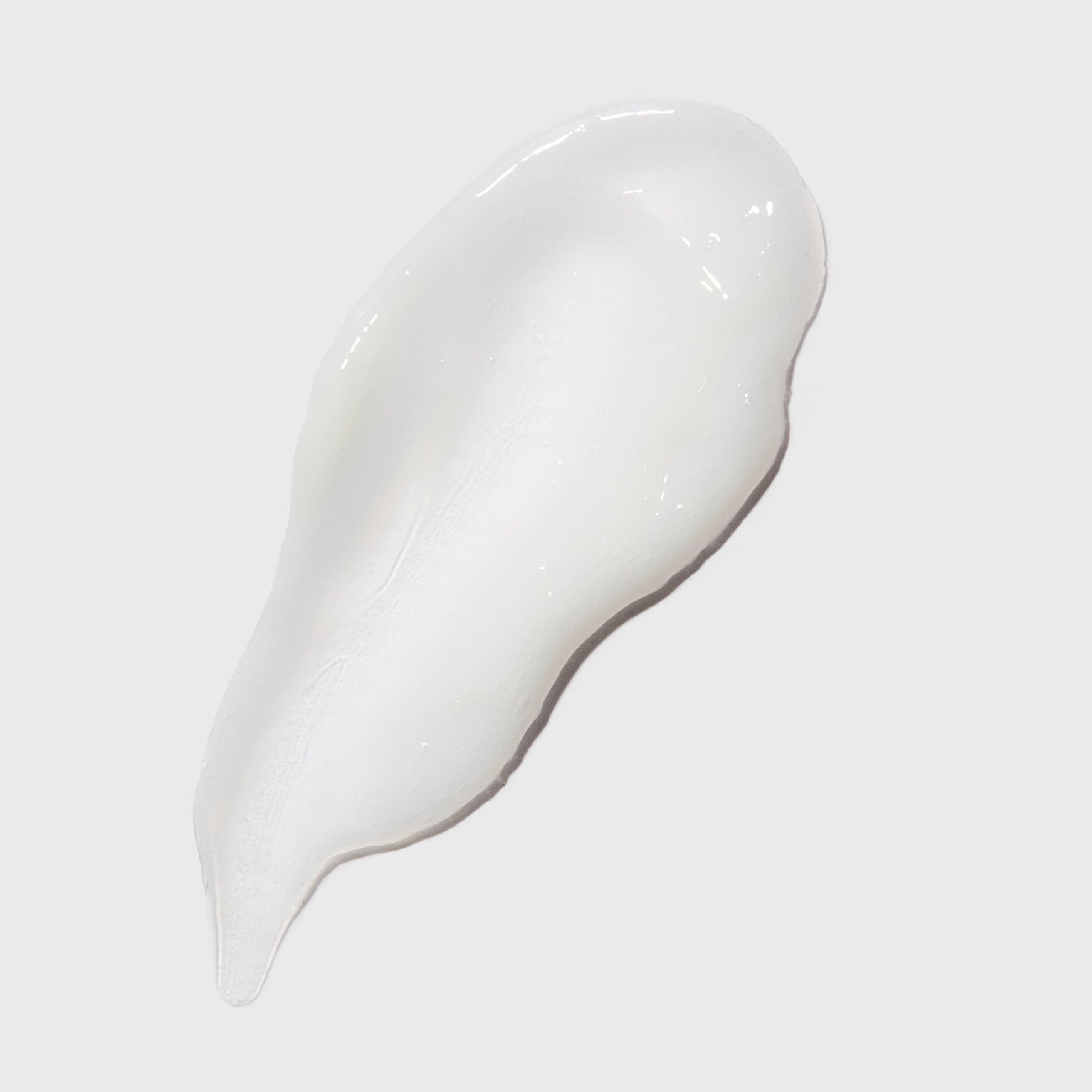 White cream or gel on a light gray background