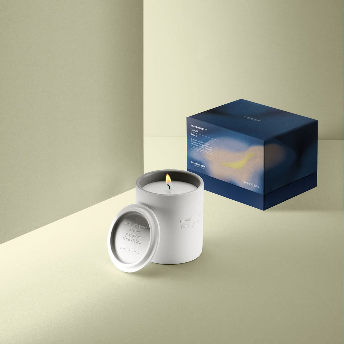 Comfort Zone holiday candle lit beside its lid and gift box