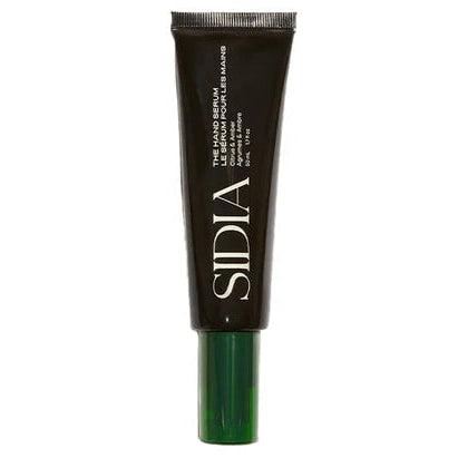 Black skincare serum tube with green cap on a white background