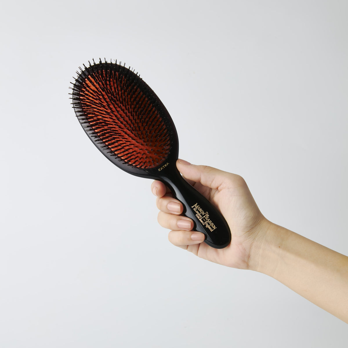 Mason Pearson Large Extra Pure Boar Bristle Hairbrush B1 in Dark Ruby — held in hand to show the brush size