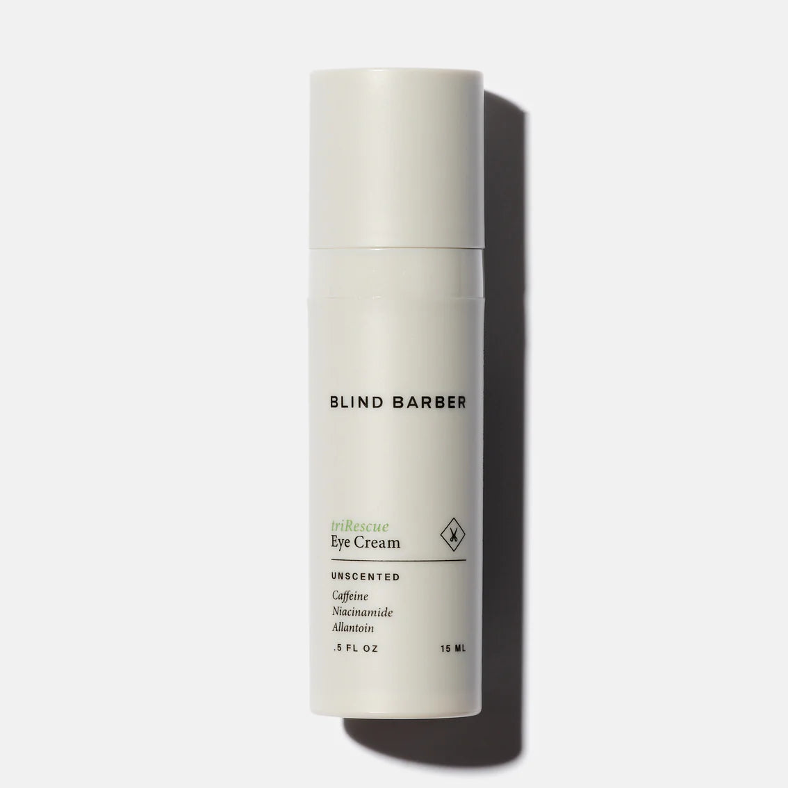 White eye cream bottle with 'Blind Barber' branding on a light gray background