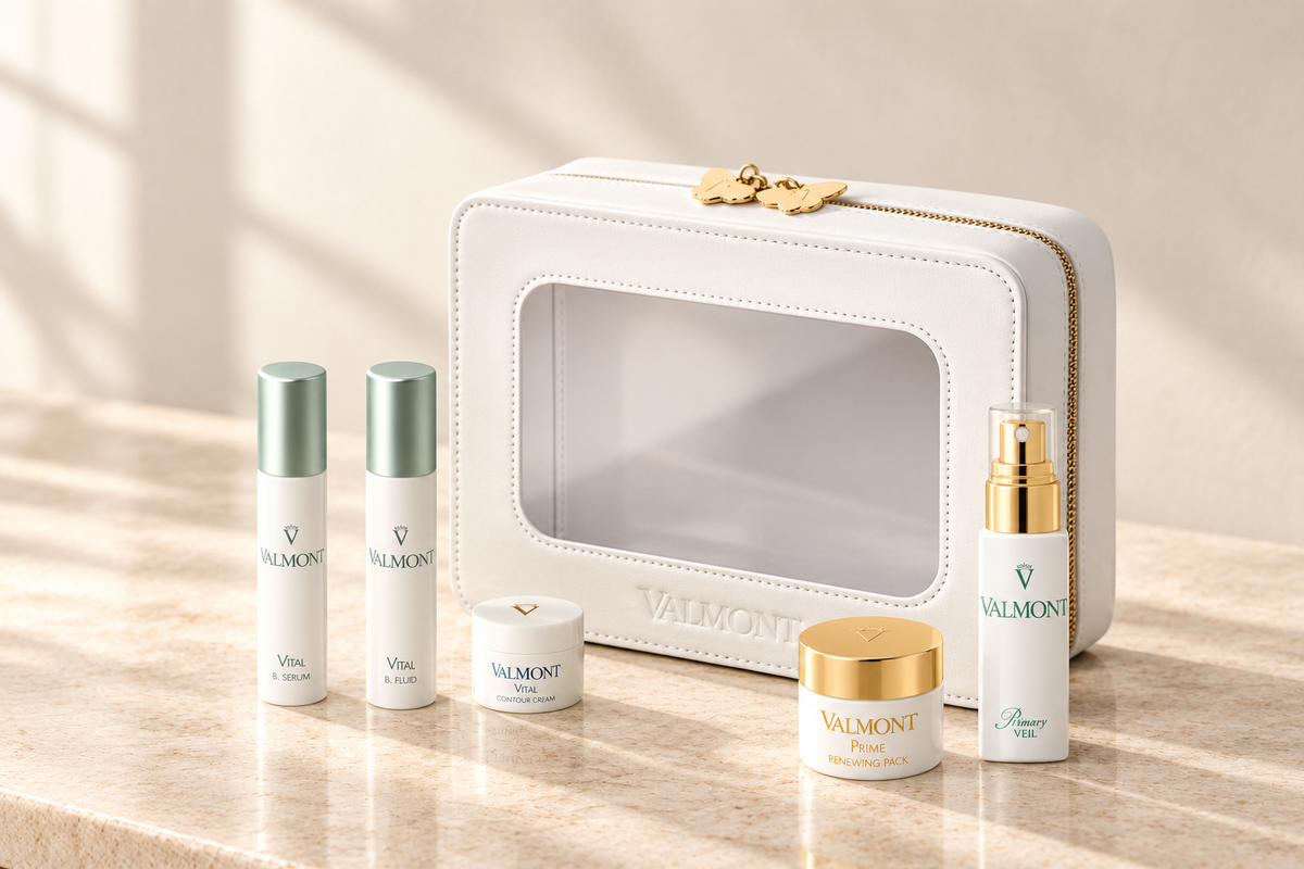 Valmont skincare discovery set with its white travel case, arranged on ivory stone in soft daylight.