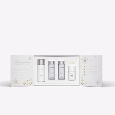 Skincare product set with four bottles in a decorative box on a white background