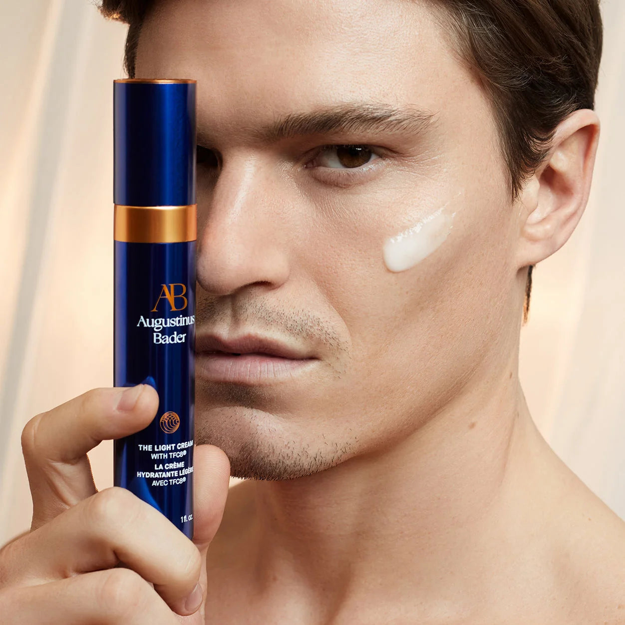 Applying Augustinus Bader The Light Cream moisturizer to the face