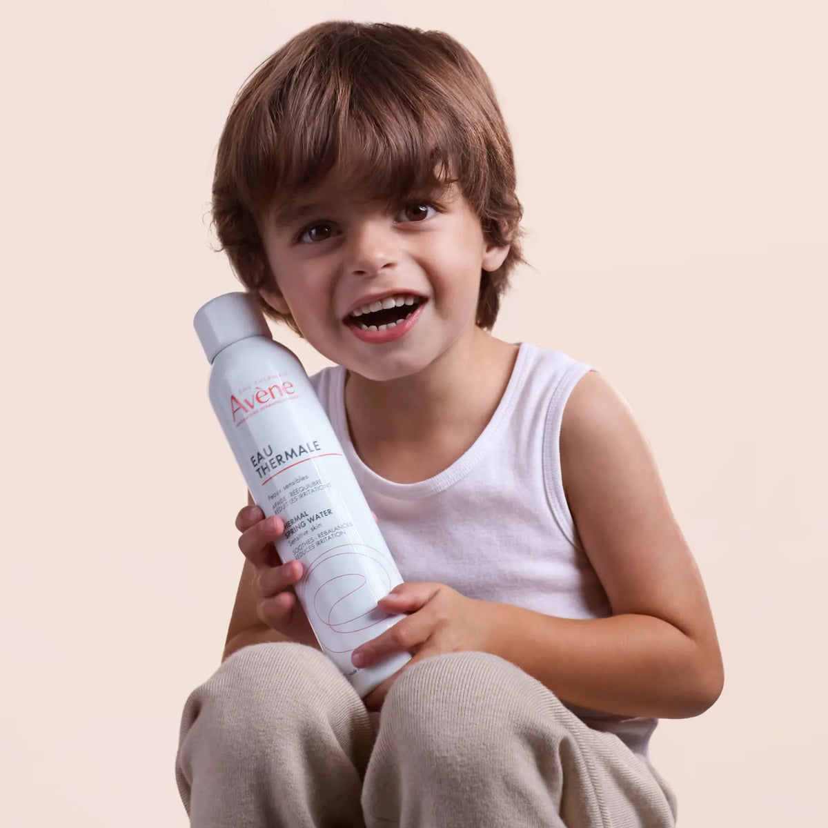 Eau thermale Avène tenue par un enfant