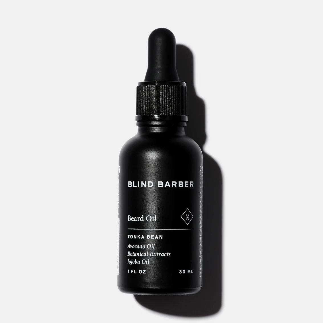 Black bottle of Blind Barber beard oil on a white background