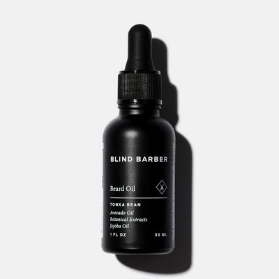 Black bottle of Blind Barber beard oil on a white background