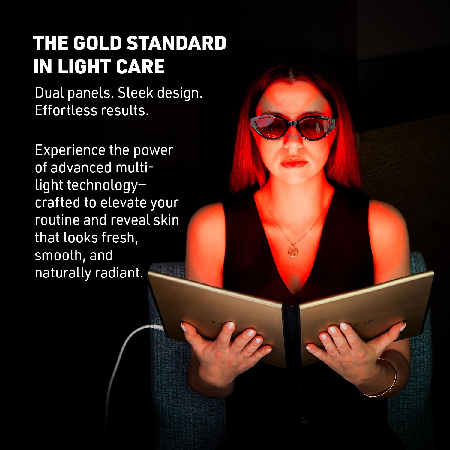 A woman wearing dark sunglasses sits in a dim setting holding an open book, with dramatic red-orange light reflecting off her face and hands. Large white text on the left reads, 'THE GOLD STANDARD IN LIGHT CARE' with descriptive copy about dual panels and light technology.