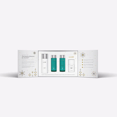 Skincare product set with three bottles in a decorative box on a white background