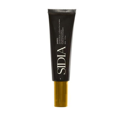 Black cosmetic tube with gold base on a white background