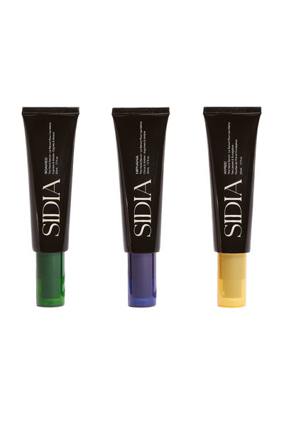 Three Sidia cosmetic tubes with different colored applicators on a white background