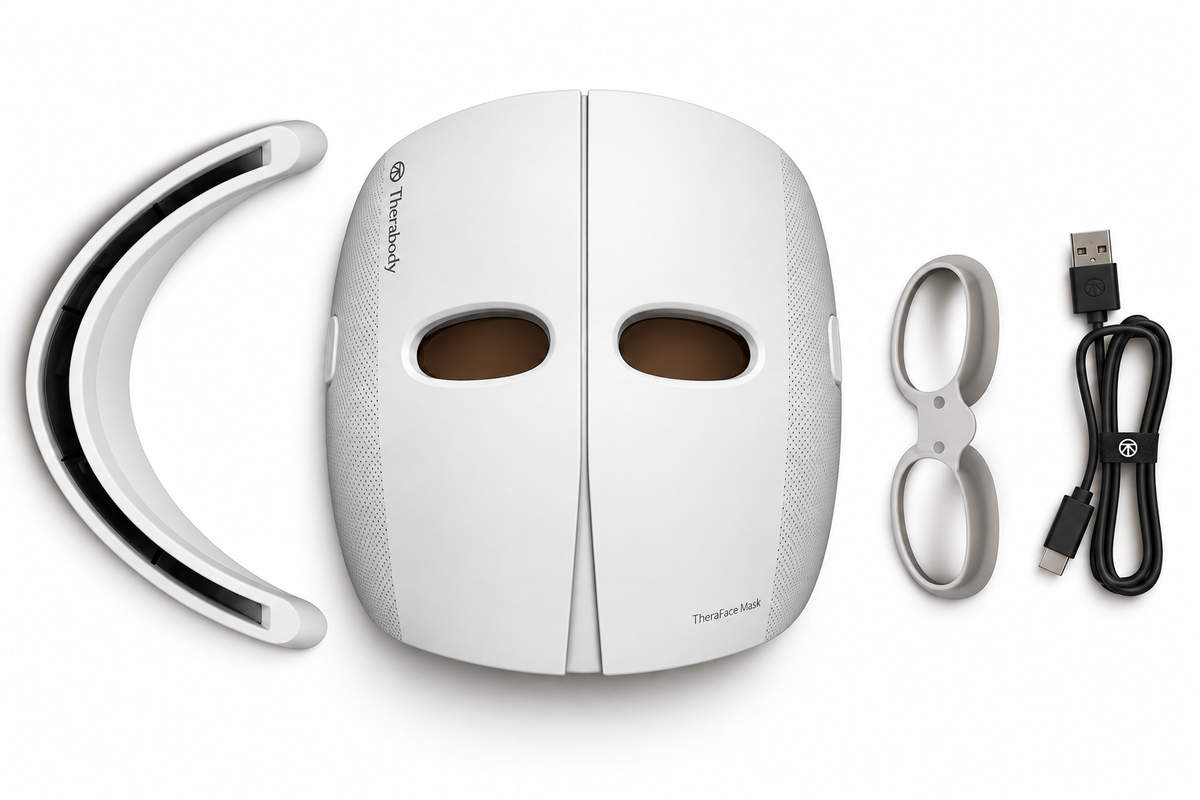 TherapyMask white LED face mask shown with its curved headband, silver ear loops, and black USB charging cable on a clean white background.