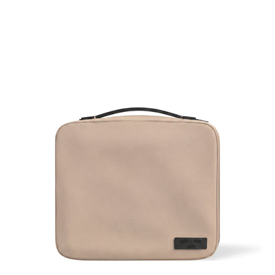 Trousse de voyage The Bag Clean Skin Club, sable, avec poignée noire, sur fond blanc