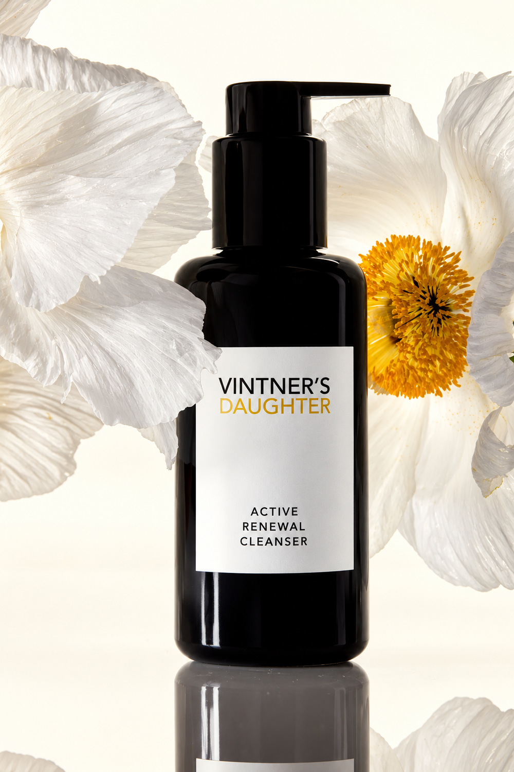Vintner’s Daughter Active Renewal Cleanser framed by delicate white flowers with golden centres on an ivory background.